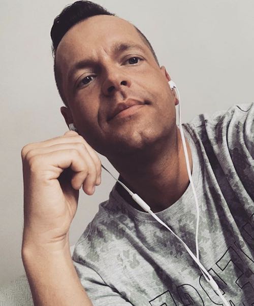 A photograph of a guy in his 40s wearing an Undercut haircut styled with a trendy quiff